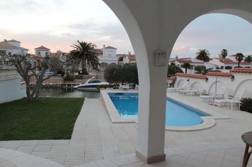 vistas a la piscina desde el patio de una villa en 'Casa Empuria' aan kanaal met zwembad en aanlegsteiger, en Empuriabrava