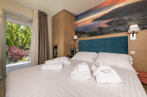 a bedroom with a large white bed with towels on it at Best Western Hotel & SPA Coeur De Cassis in Cassis