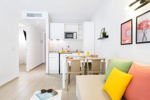 sala de estar y cocina con sofá y mesa en Apartamentos Flor los Almendros, en Paguera