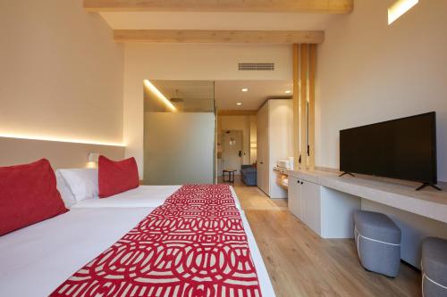 a hotel room with a large bed and a flat screen tv at Fil Suites in Palma de Mallorca