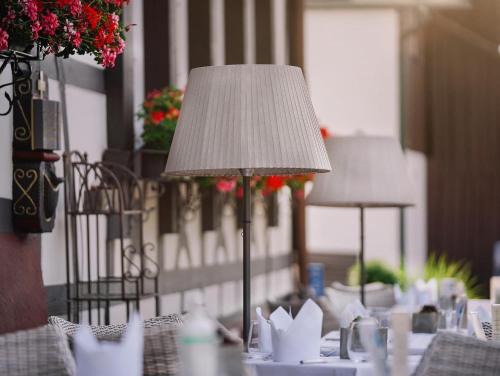 a table with a lamp on top of it at Hotel Restaurant Der Engel, Sasbachwalden in Sasbachwalden