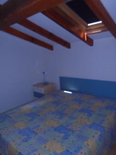 Cette chambre comprend un lit et un plafond en bois. dans l'établissement VARDIOLA/PORTO VECCHIO, à Pinarellu