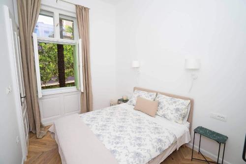Un dormitorio blanco con una cama y una ventana. en Villa Gisela, en Opatija