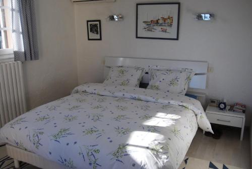 une chambre avec un lit avec une couette bleue et blanche dans l'établissement Villa Saint-Aygulf, à Saint-Aygulf