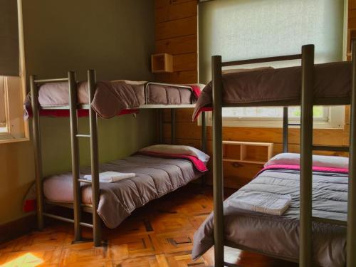 a room with three bunk beds in it at Carving Surf Hostel in San Esteban de Pravia