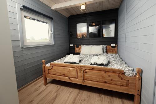 una camera con letto in legno e finestra di Dragonfly Lake House εïз a Limbaži