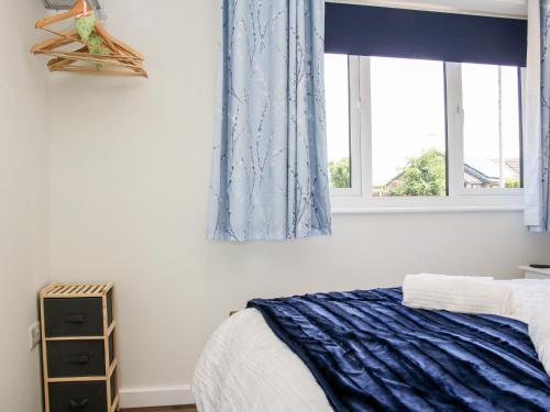 a bedroom with a bed and two windows at Oakleigh in Llanymynech
