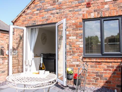 a brick building with a patio with a table and chairs at Oakleigh in Llanymynech