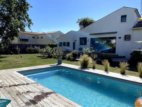 une piscine devant une maison dans l'établissement Havre de paix quartier du parc Royan meublé de tourisme classée 4 étoiles, à Royan