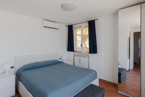 a bedroom with a blue bed and a window at Penthouse with Jacuzzi on Private Terrace in Trastevere in Rome