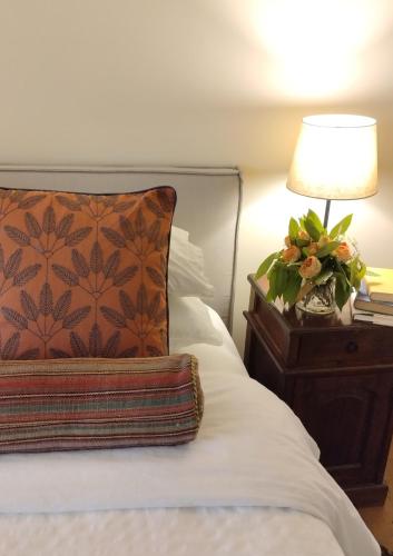 a bed with a pillow and a lamp on a night stand at Villa Giara in Calosso