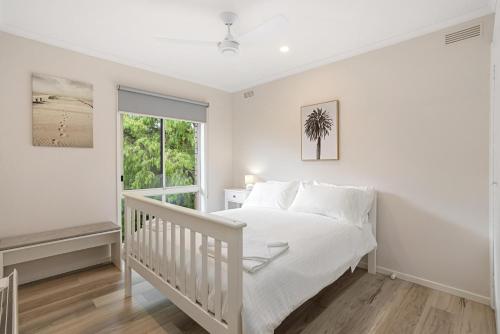 a white bedroom with a bed and a window at Sorrento Lifestyle Awaits in Sorrento