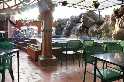a water park with tables and chairs and a fountain at Parklane Hotel in Mysore
