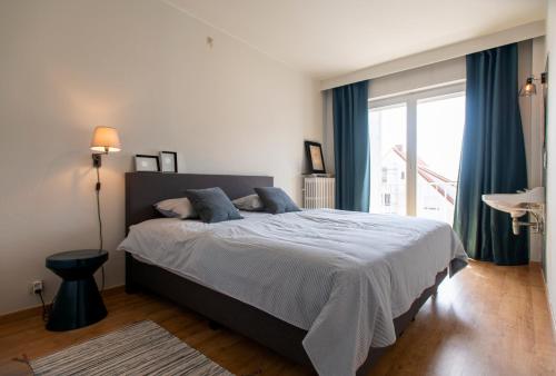 - une chambre avec un grand lit et des rideaux bleus dans l'établissement Endless Sea View, à Knokke-Heist