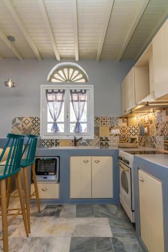 a kitchen with white cabinets and a blue counter top at Θἔρως (Theros) house 3- Agios Fokas in Agios Sostis
