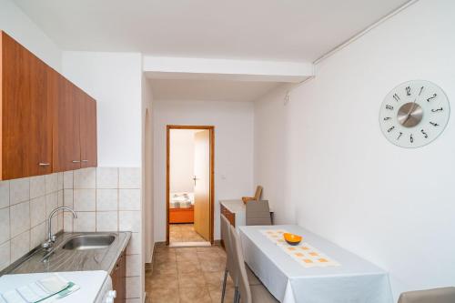 a kitchen with a sink and a clock on the wall at Apartments Villa Cerjak in Slano