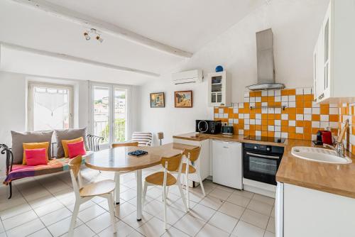 une cuisine et une salle à manger avec une table et des chaises dans l'établissement Le Clocher par Dodo-a-Cassis, à Cassis