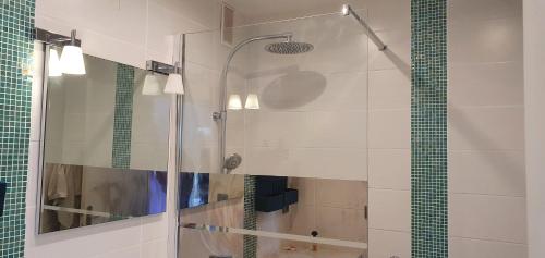 une douche avec une porte vitrée dans une salle de bain dans l'établissement beau t2 proche plage et commerces, logia, à La Grande Motte