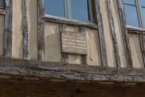 un panneau sur le côté d'un bâtiment dans l'établissement La Maison Pavie, à Dinan