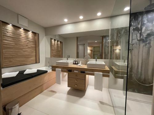 a bathroom with two sinks and a large mirror at SPA & Relax Hotel Erika in Tirolo