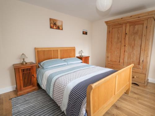 a bedroom with a bed with a blue and white blanket at The Old Gate House Annexe in Alford