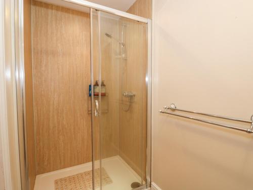 a shower with a glass door in a bathroom at The Old Gate House Annexe in Alford