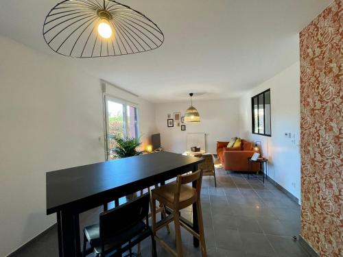 a dining room and living room with a table and chairs at La Cabane du Loft in Genas