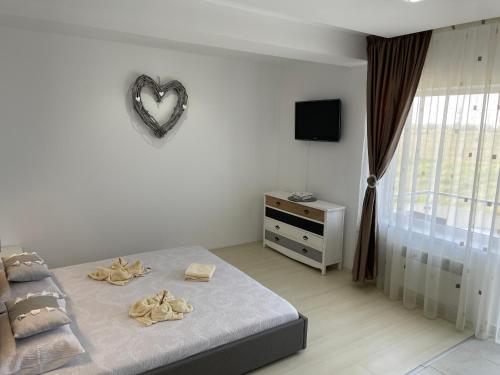 ein Schlafzimmer mit einem Bett und einem Herz an der Wand in der Unterkunft Luxory Apartaments 2 in Costinești