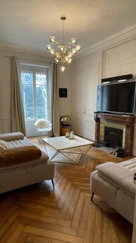 d'un salon avec une cheminée et un lustre. dans l'établissement Belges, à Lyon