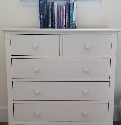 a white dresser in a bedroom with books at Solheimir at Strathmore Golf Course in Blairgowrie