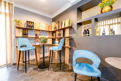 a bar with blue chairs and bottles of wine at Albergo Locanda Primavera in Rodengo Saiano