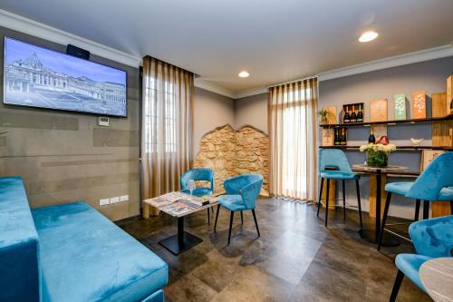 a waiting room with blue chairs and a tv at Albergo Locanda Primavera in Rodengo Saiano