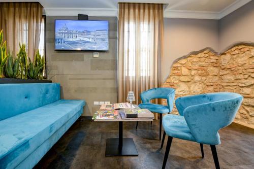 a living room with blue furniture and a table and chairs at Albergo Locanda Primavera in Rodengo Saiano