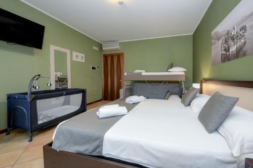 a bedroom with a large bed and a television at Albergo Locanda Primavera in Rodengo Saiano