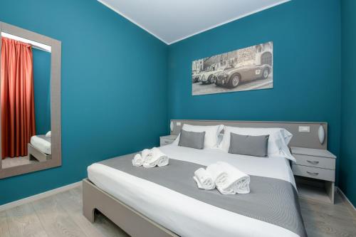 a bedroom with a large bed with blue walls at Albergo Locanda Primavera in Rodengo Saiano