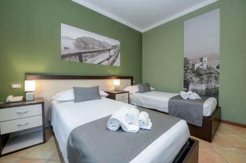 a hotel room with two beds with towels on them at Albergo Locanda Primavera in Rodengo Saiano