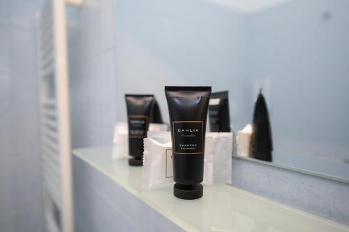 a shelf with three products in front of a mirror at Albergo Locanda Primavera in Rodengo Saiano