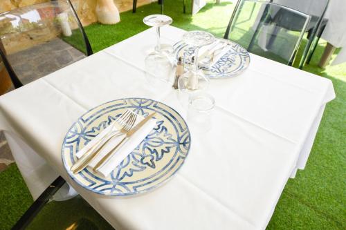 a white table with blue and white plates on it at Albergo Locanda Primavera in Rodengo Saiano
