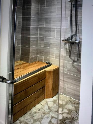 y baño con ducha y bañera de madera. en Petit coin de paradis, en Vals-les-Bains