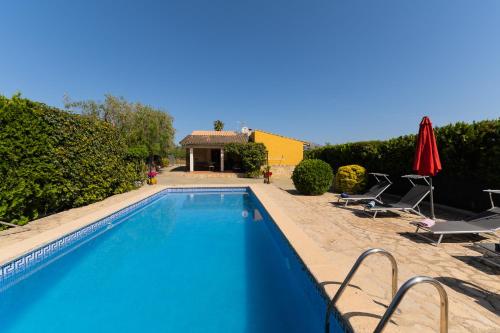 una piscina con sillas y una casa en Sa Sini Cozy country villa for 6 near Buger, en Búger