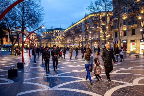 a group of people walking down a city street at Central Baku Luxury Apartment on Nizami Street in Baku