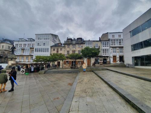 a group of people walking in a city with buildings at Casa Herbellas in Cedeira