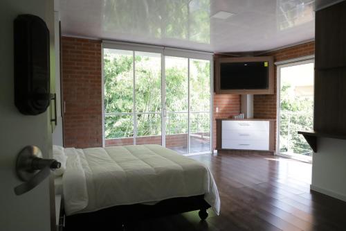 a bedroom with a bed and a large window at Cucaña Hotel in El Pedregal