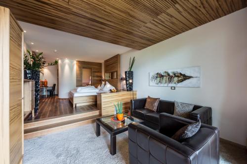 a living room with a couch and a bed at SPA & Relax Hotel Erika in Tirolo