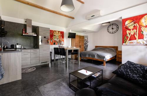 a kitchen and a living room with a couch and a table at Brabants Genieten in Kaatsheuvel