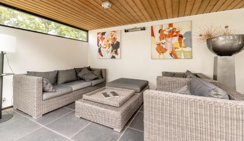 a living room with wicker chairs and a couch at Brabants Genieten in Kaatsheuvel