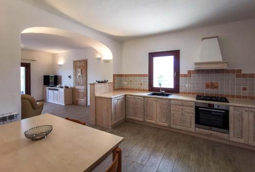a large kitchen with wooden cabinets and a table at Casa Aurora in San Pantaleo