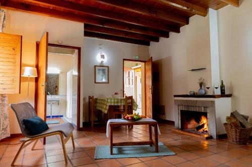 a living room with a fireplace and a table at Quinta Do Crestelo Aparthotel in Seia