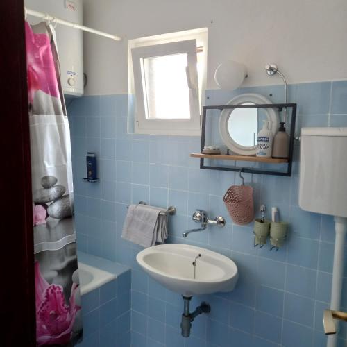 a blue tiled bathroom with a sink and a mirror at Kuća za odmor Skalina - Sea view in Splitska