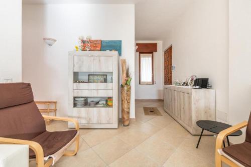 ein Wohnzimmer mit einem Schrank und einem Tisch in der Unterkunft Casa a 50 passi dalla spiaggia in Capoterra